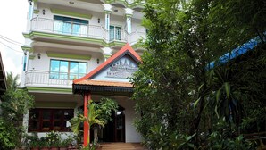 A multi-story building with balconies, a red roof, and a traditional architectural design. - Damnak Riverside Villa (Siem Reap)