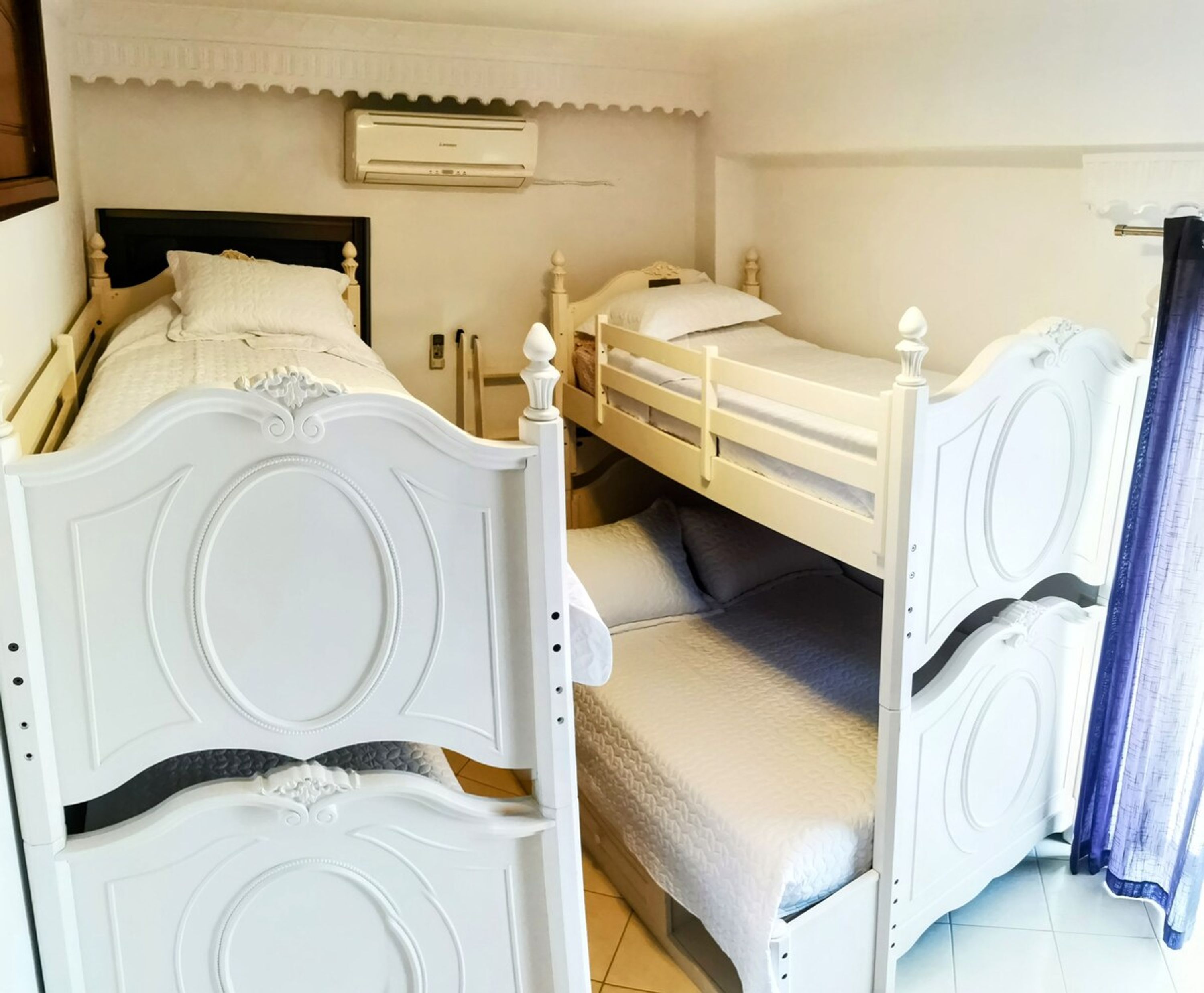 Ein Schlafzimmer mit zwei Etagenbetten, einem Deckenventilator und einer Klimaanlage.