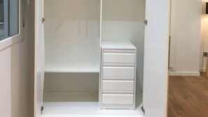 A walk-in closet with a sliding door, built-in shelves, and a storage unit with drawers. - Next to the Silk Exchange and Central Market (Valencia)