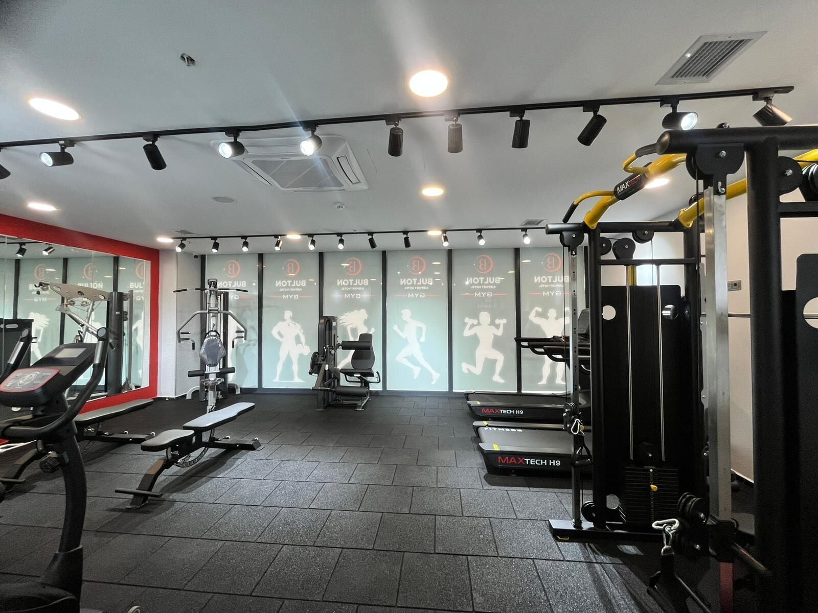 A gym with treadmills, weight machines, and mirrors.