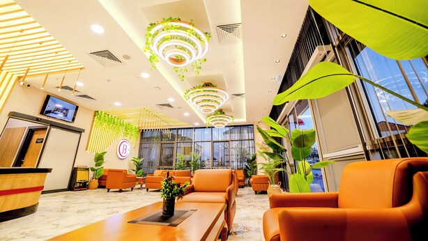 A modern hotel lobby with a reception desk, seating area, and large windows. - Bulton Hotel Airport (Arnavutköy)