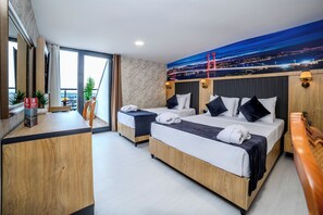A hotel room with two beds, a desk, and a large window with a cityscape view.
