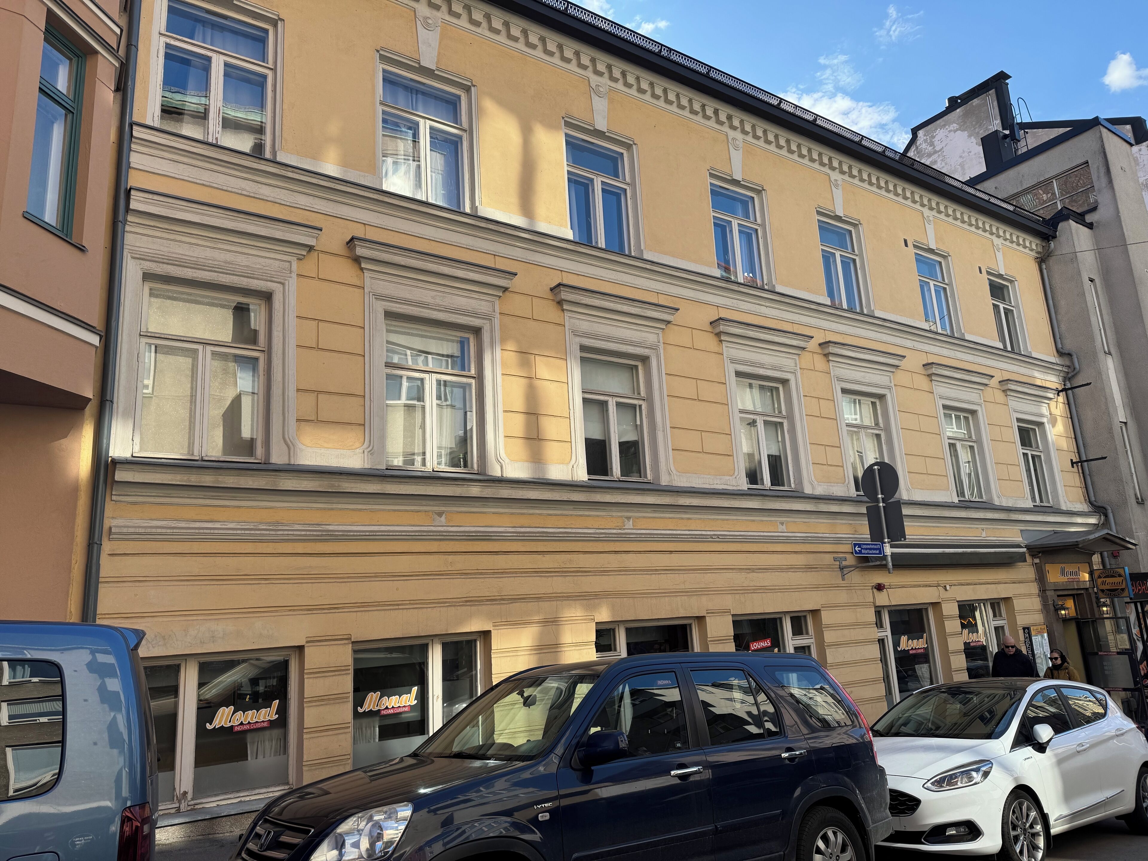 En bygning med mange vinduer og en butiksvindue med et skilt der står "Monal".