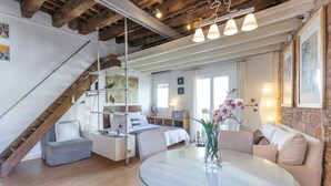 A spacious living area with a staircase, a dining table, and a sofa. - Stay U-nique Apartments Monec (Barcelona)