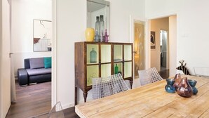 A dining area with a wooden table, chairs, and a cabinet with glass doors.