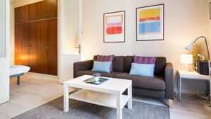 Una sala de estar moderna con un sofá, una mesa de centro y un escritorio con una lámpara.