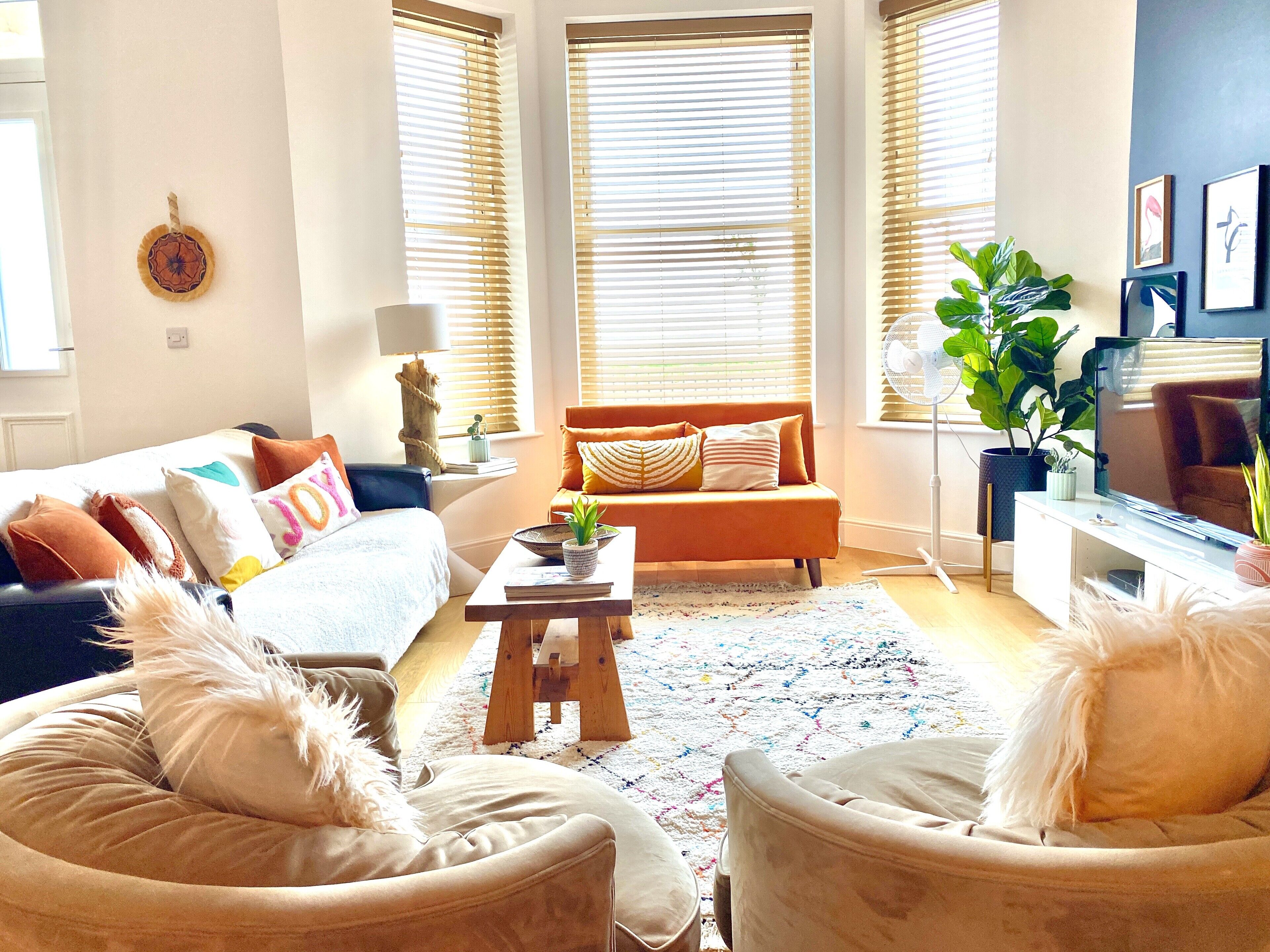 Un salon comprenant un canapé, des fauteuils, une table basse et un téléviseur.