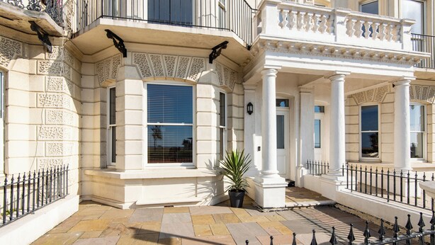 A classical building with ornate columns, large windows, and a black wrought iron fence. - Stunning 2 Bed Apartment on the beach by Urban Roost (Worthing)