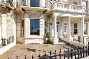 A classical building with ornate columns, large windows, and a black wrought iron fence. - Stunning 2 Bed Apartment on the beach by Urban Roost (Worthing)