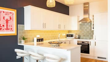 Apartamento superluxo, 2 quartos, aceita animais de estimação, vista para a praia | Cozinha privada | Cadeirão de bebê