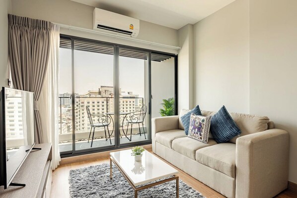 A modern living room with a sofa, coffee table, and a TV.