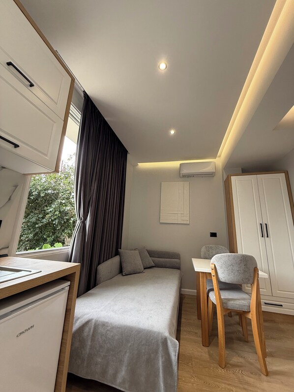 A modern bedroom with a bed, a desk, a chair, and a wardrobe. - Maison Apartments (Vlore)