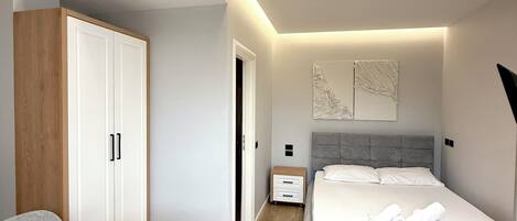 Un dormitorio moderno con una cama, una mesita de noche y un escritorio con una silla.