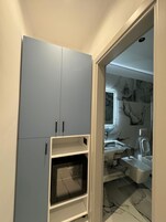 Et badeværelse med marmorbeklædt bagvæg, vask og toilet.