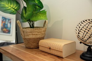 A woven basket with a plant, a woven box, and a woven lamp on a wooden surface. - Nobia 3 (Athens)