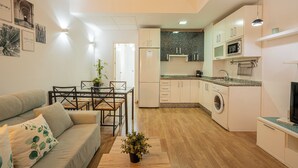 A compact living space with a kitchenette, a dining area, and a sofa. - Stay U-nique Apartment Trinidad (Málaga)