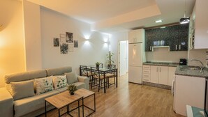 A modern apartment with a living room, dining area, and kitchen. - Stay U-nique Apartment Trinidad (Málaga)
