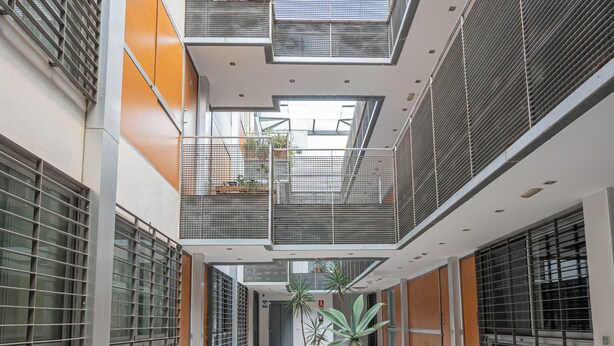 A modern building with a central atrium, large windows, and a tiled floor. - Stay U-nique Apartment Trinidad (Málaga)