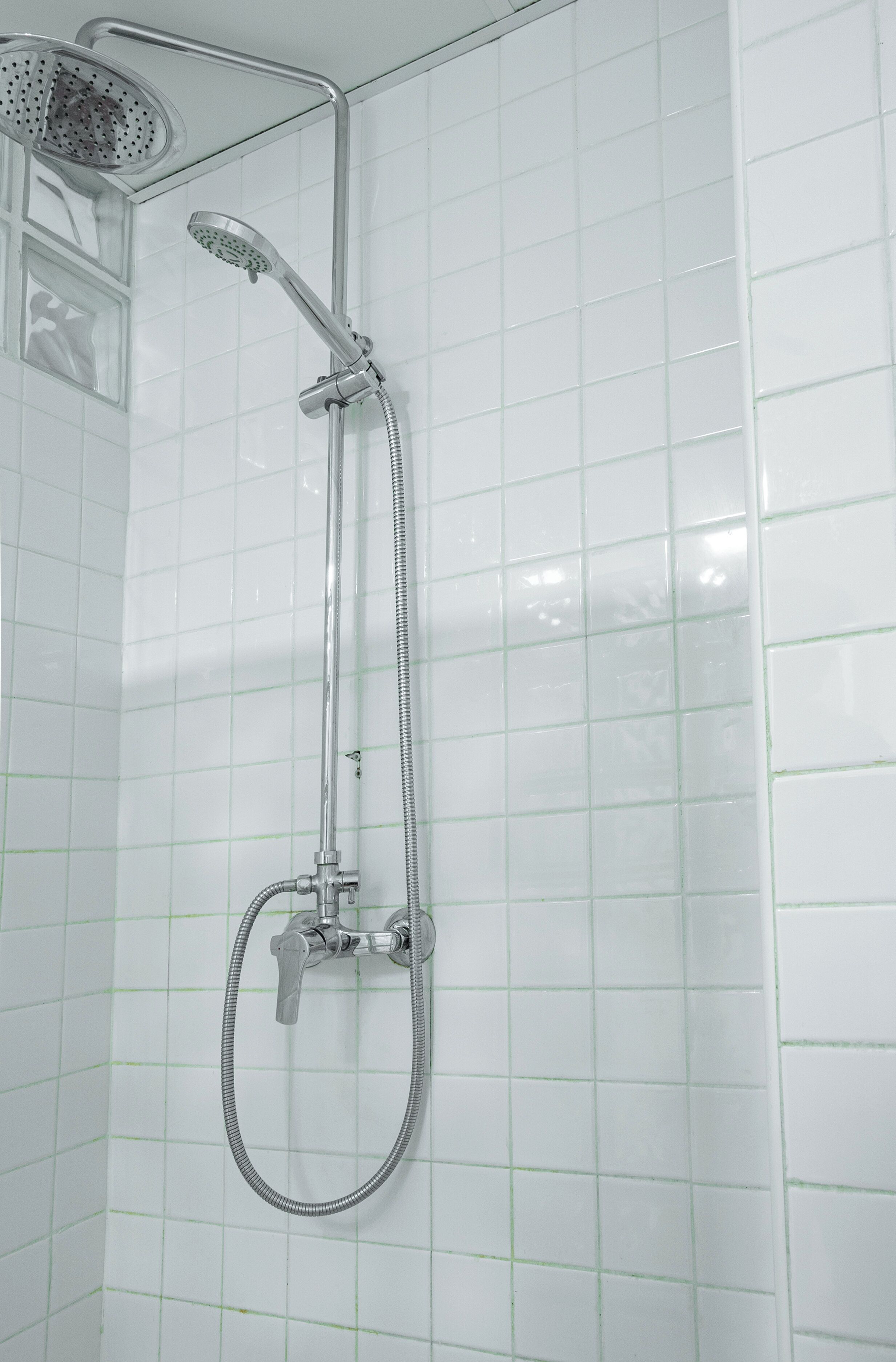 A shower with a handheld showerhead and a flexible hose.