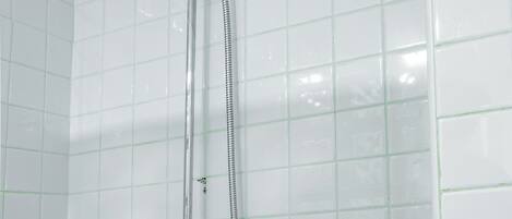 A shower with a handheld showerhead and a flexible hose.