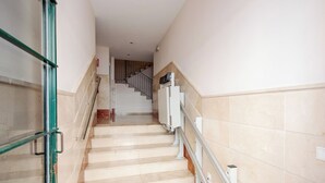 A staircase with a handrail, leading to a landing with a door. - Stay U-nique Apartment Alderete (Málaga)