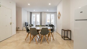 Une cuisine moderne avec une table à manger, des chaises et un réfrigérateur.