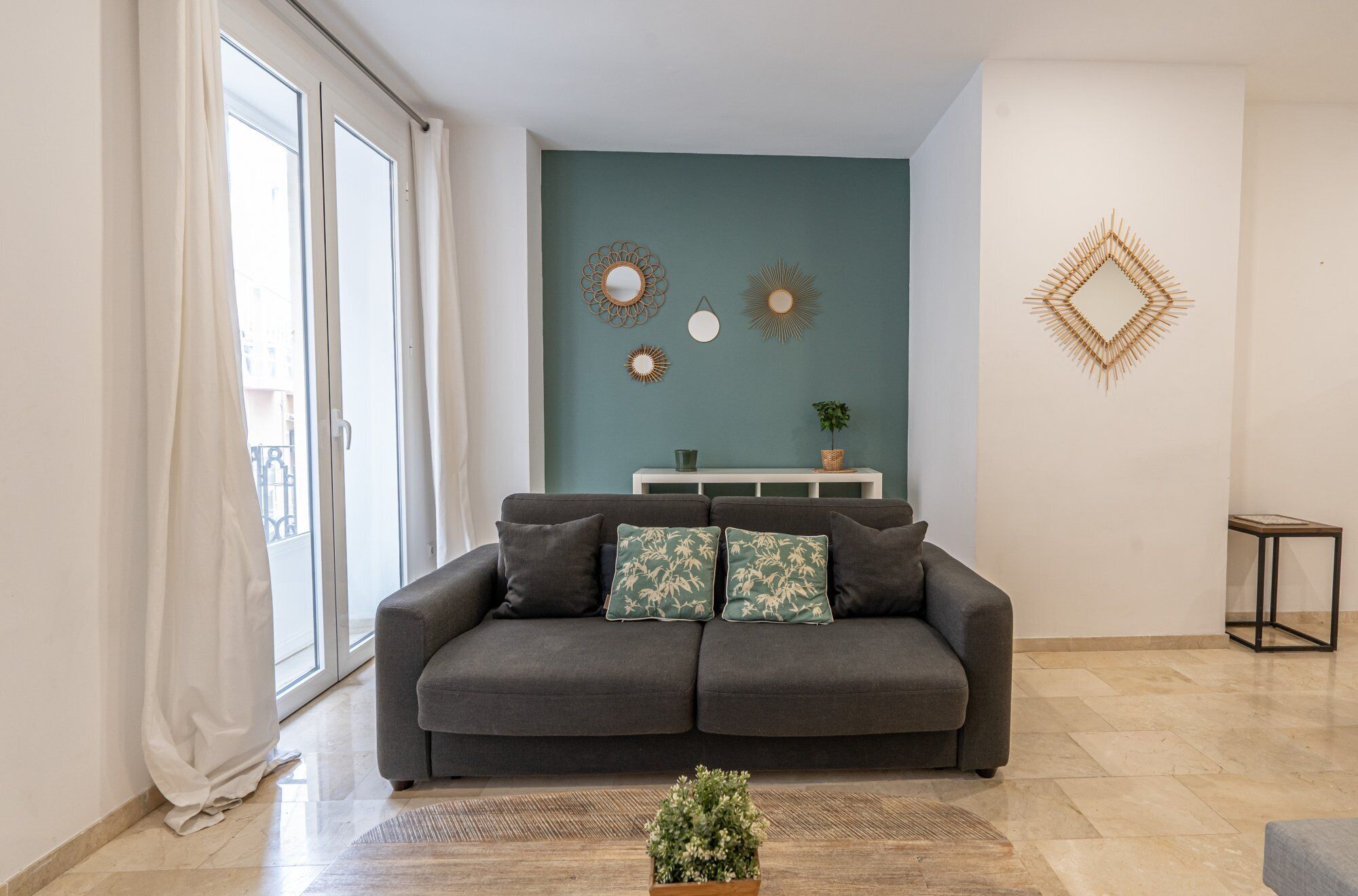 A modern living room with a grey sofa, a white console table, and decorative wall art.