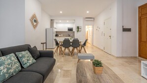 Un salon moderne comprenant un canapé, une table basse et un coin repas avec des chaises et une table.