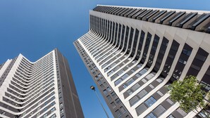 Dos edificios altos con un diseño arquitectónico moderno, que incluyen una serie de balcones y ventanas amplias.