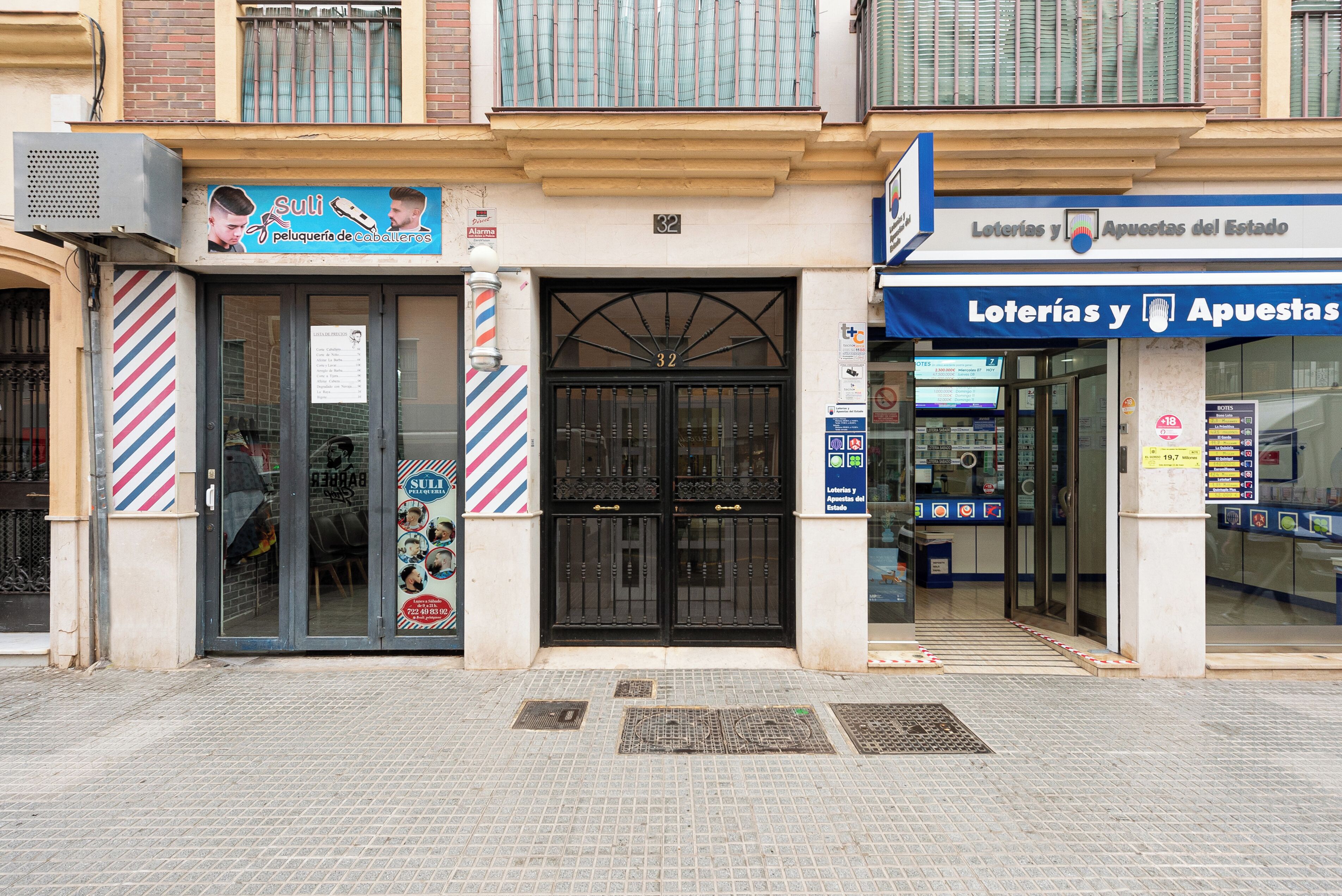 Um edifício com um barbearia no andar térreo e uma agência de loteria no segundo andar.