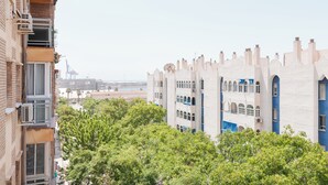 Un immeuble à plusieurs étages, doté de balcons et offrant une vue sur une étendue d’eau lointaine.