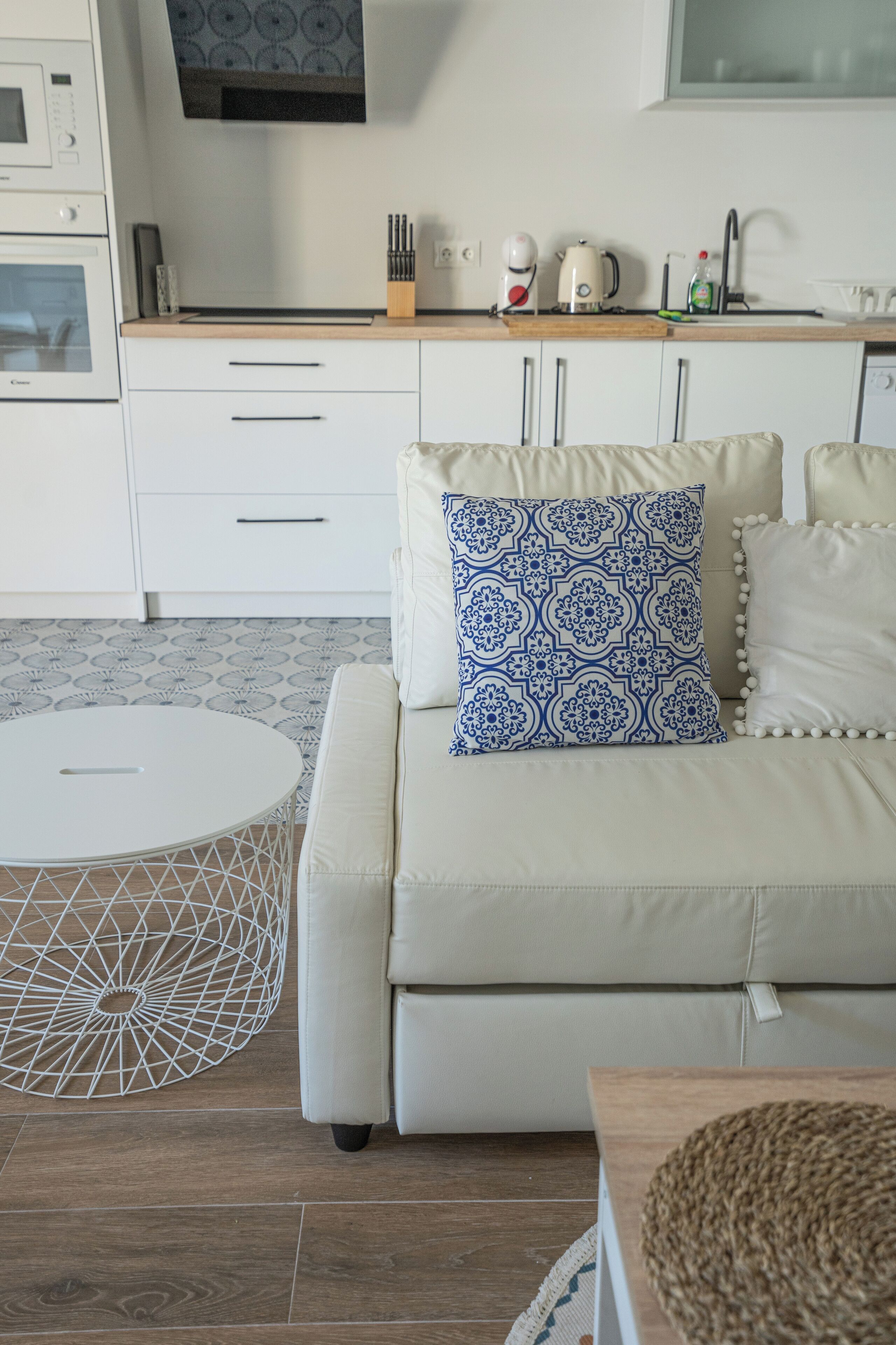 A modern kitchen with white cabinets, a white countertop, and a built-in oven.