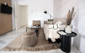 A modern living room with a sofa, ottoman, coffee table, and a side table with a lamp. - Stay U-nique Apartments Plaza Constitución (Málaga)