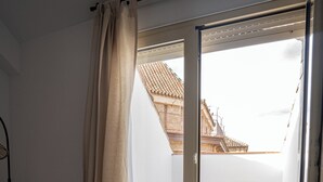 A small balcony with a tiled floor, a wooden table, and a chair. - Stay U-nique Apartments Plaza Constitución (Málaga)