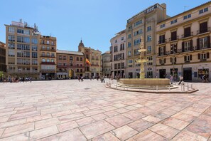 A spacious public square with a central fountain, surrounded by historic buildings with balconies and shops. - Stay U-nique Apartments Plaza Constitución (Málaga)