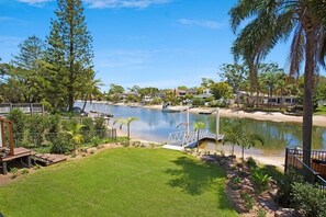 A residential area with a lake, a dock, and a well-maintained lawn.
