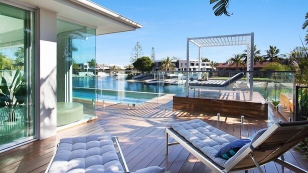 A modern outdoor pool area with lounge chairs and a glass-enclosed patio. - Sanctuary Waterfront – Coastal Elegance in the Heart of Broadbeach Waters (Gold Coast)