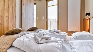 Une chambre à coucher moderne avec une grande fenêtre, des éléments décoratifs en bois et un design minimaliste.