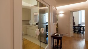 Une cuisine moderne dotée d’une porte en verre, d’un plancher en bois et d’un coin repas avec une table et des chaises.