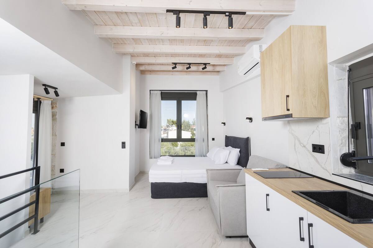 Un dormitorio moderno con cama, mesita de noche y vistas al exterior.