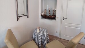 A room with a small table, two chairs, a mirror, and a door. - 700 m from the beach, affordable and elegant. We are family and pet friendly (Heringsdorf)
