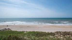 A beach with a wooden walkway leading to the shore.