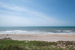 Una playa con un paseo de madera que conduce a la orilla.