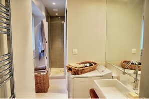 Une salle de bain moderne avec une douche, un lavabo et un miroir.