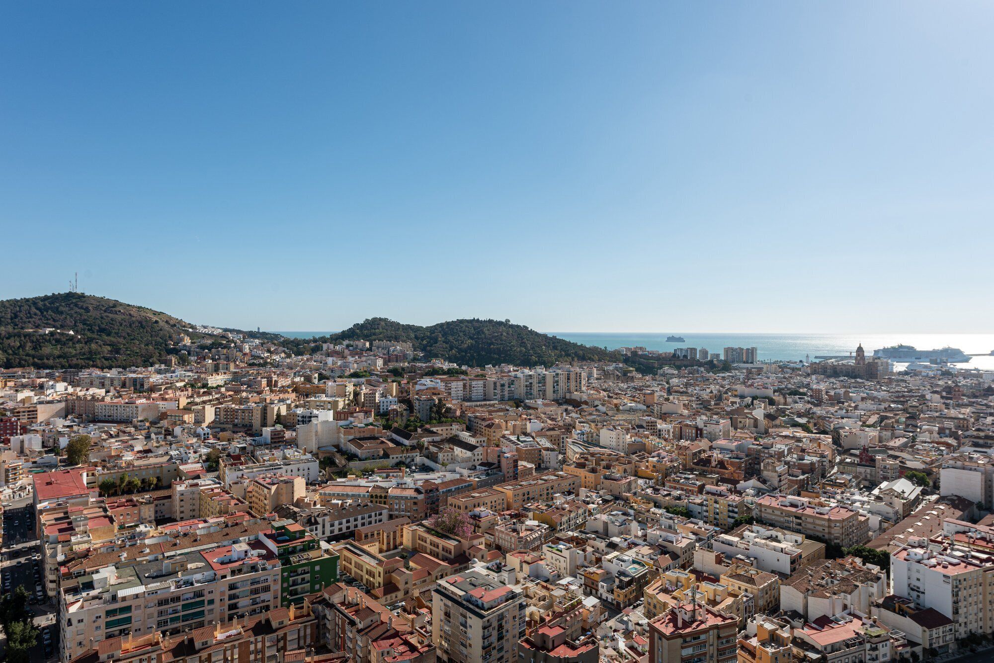 Una zona urbana densa con diversos tipos de edificios y un telón de fondo montañoso.