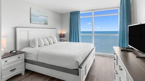 Una camera da letto con un letto grande, una televisione, un comodino e una finestra vista mare.