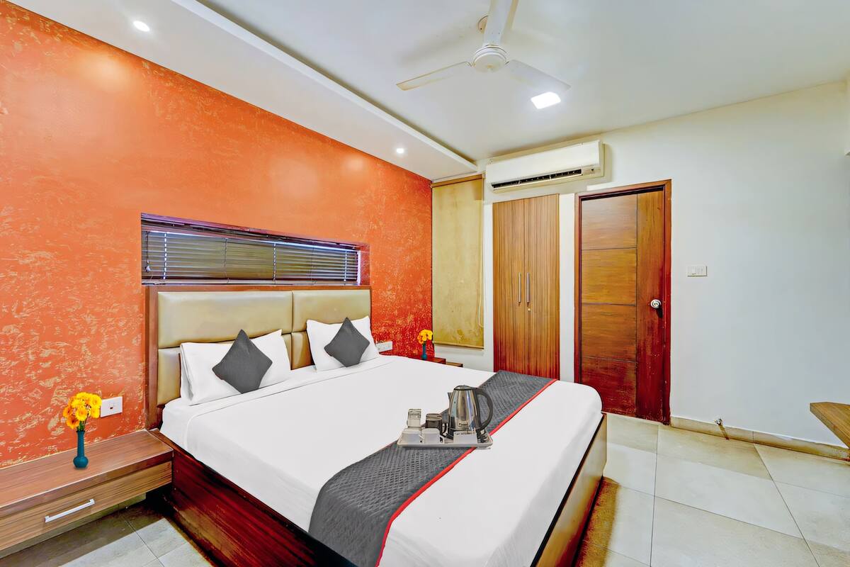 Una habitación de hotel con cama, ventilador de techo, aire acondicionado y armario.