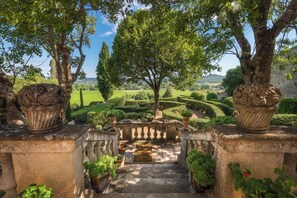 A stone staircase leading to a garden with a large tree and a view of the countryside. - Château de Saint Siffret Listed park and private swimming pool (Saint-Siffret)