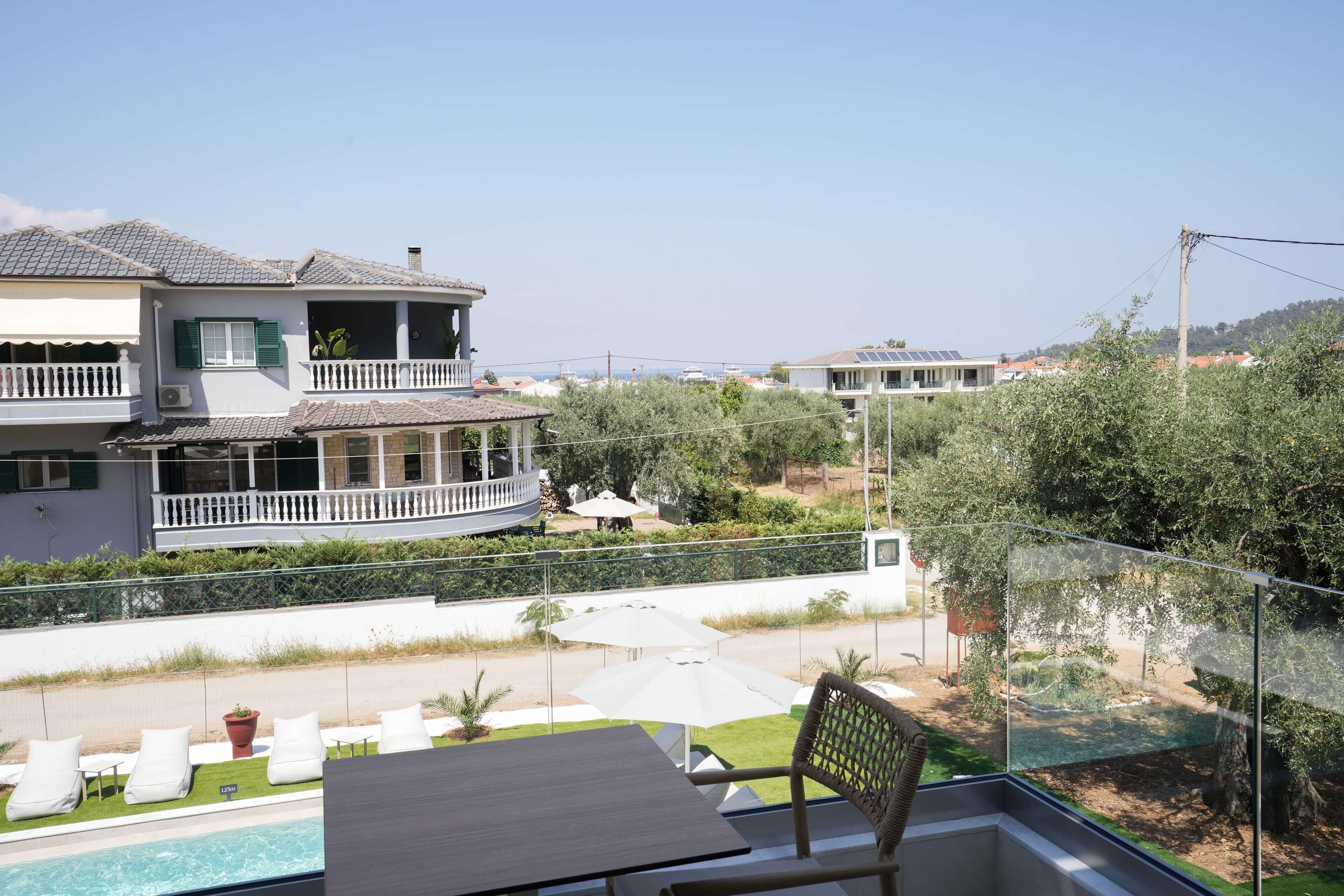 Ein Wohnhaus mit Swimmingpool, Sitzgelegenheiten im Freien und Blick auf benachbarte Häuser.