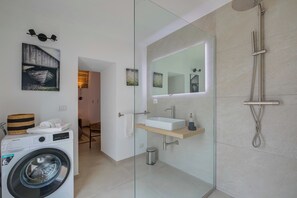 A modern bathroom with a washing machine, a glass shower enclosure, and a sink with a mirror. - Private Oasi With Spa and Pool (Melissano)